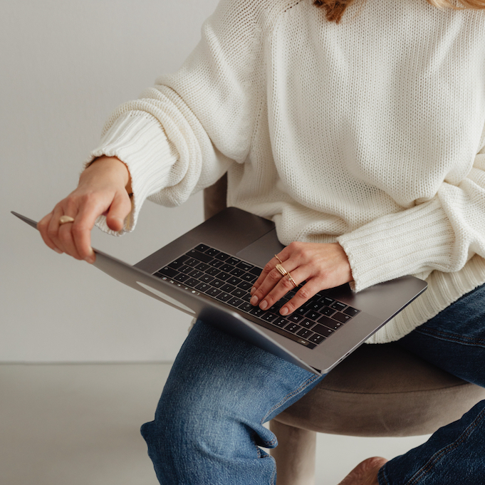 Woman holding a laptop while sitting