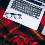 Glasses and laptop on a blanket