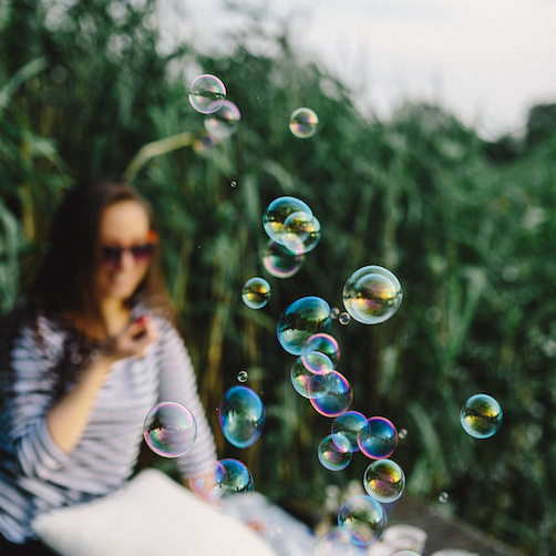 Close up of woman blowing bubbles