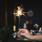 Woman holding a sparkler in a darkened room
