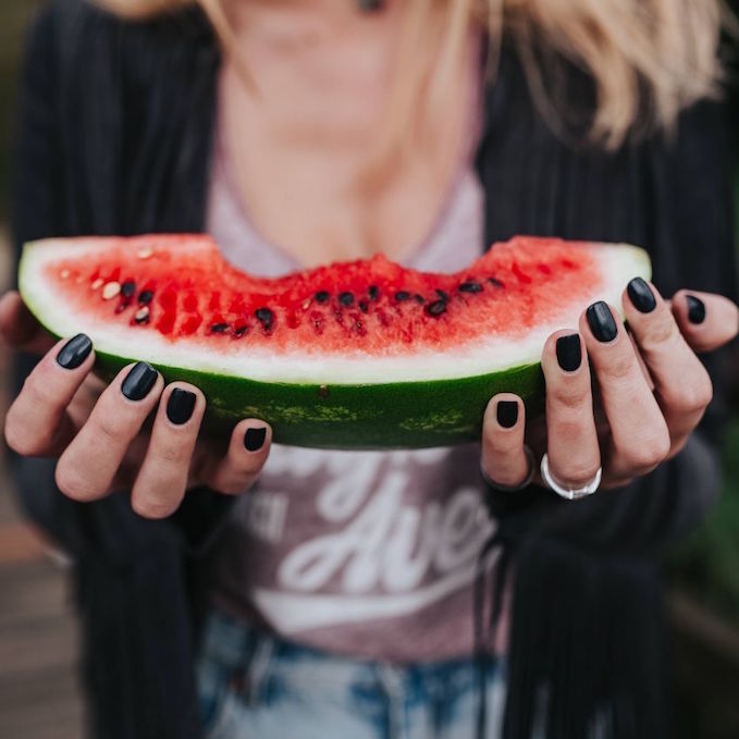 Woman holding a slice of watermelon