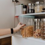 Woman removing cereal container from pantry