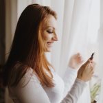 Woman smiling and looking at a cell phone