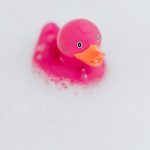 Pink rubber duck in soap bubbles