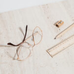 Eyeglasses, pencil, ruler, and pencil sharpener on table