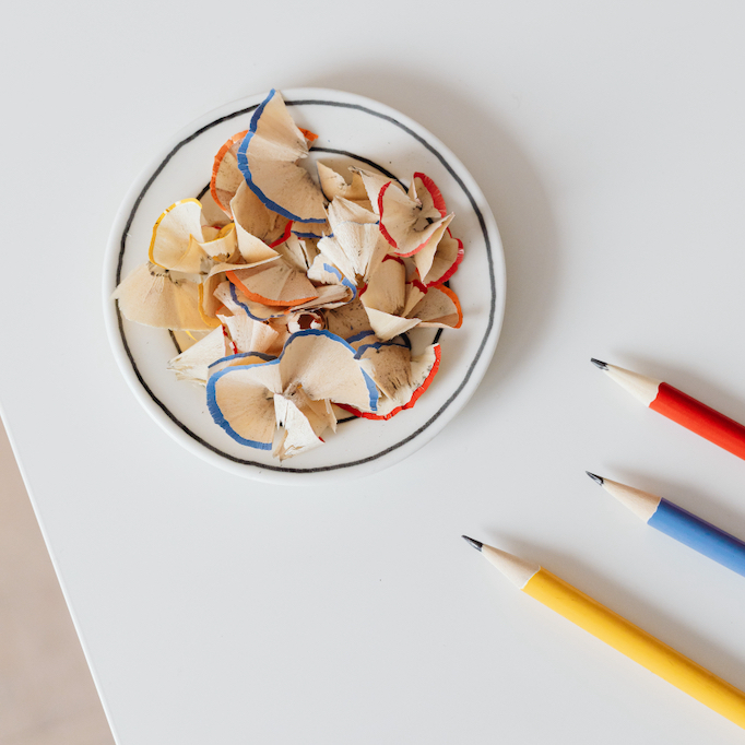 Pencils and pencil shavings in a saucer on a table