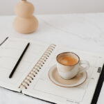 Paper planner and cup of coffee on a table