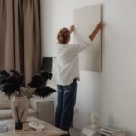 Woman hanging wall decoration in a living room