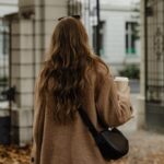 Woman walking outdoors holding a cup of coffee